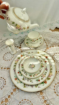 Tea set with floral patterns on a lace tablecloth