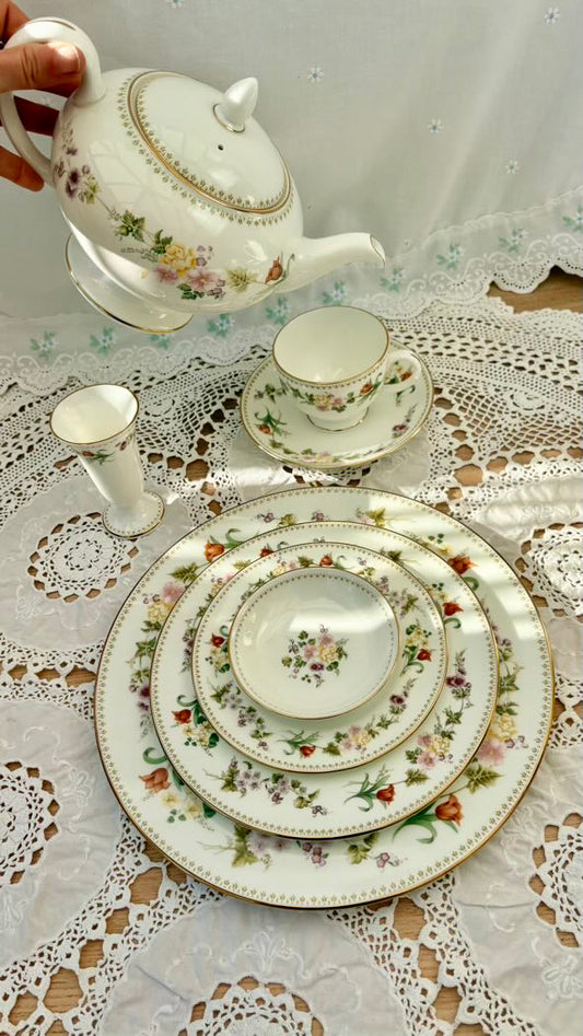 Tea set with floral patterns on a lace tablecloth