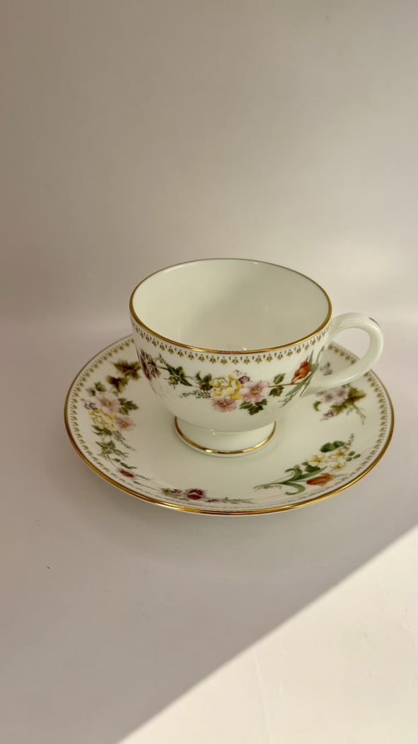 Floral teacup and saucer on a plain background