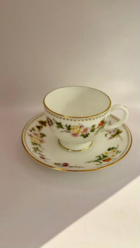 Floral teacup and saucer on a plain background
