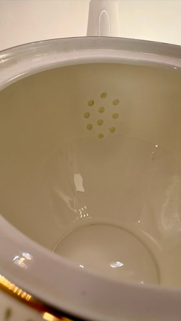 Close-up of a white ceramic pot with a lid on a light background