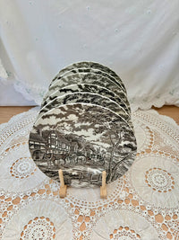 Set of six black and white ceramic coasters on a decorative stand with a lace tablecloth background.