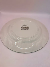 White ceramic plate with a visible brand logo on a white background