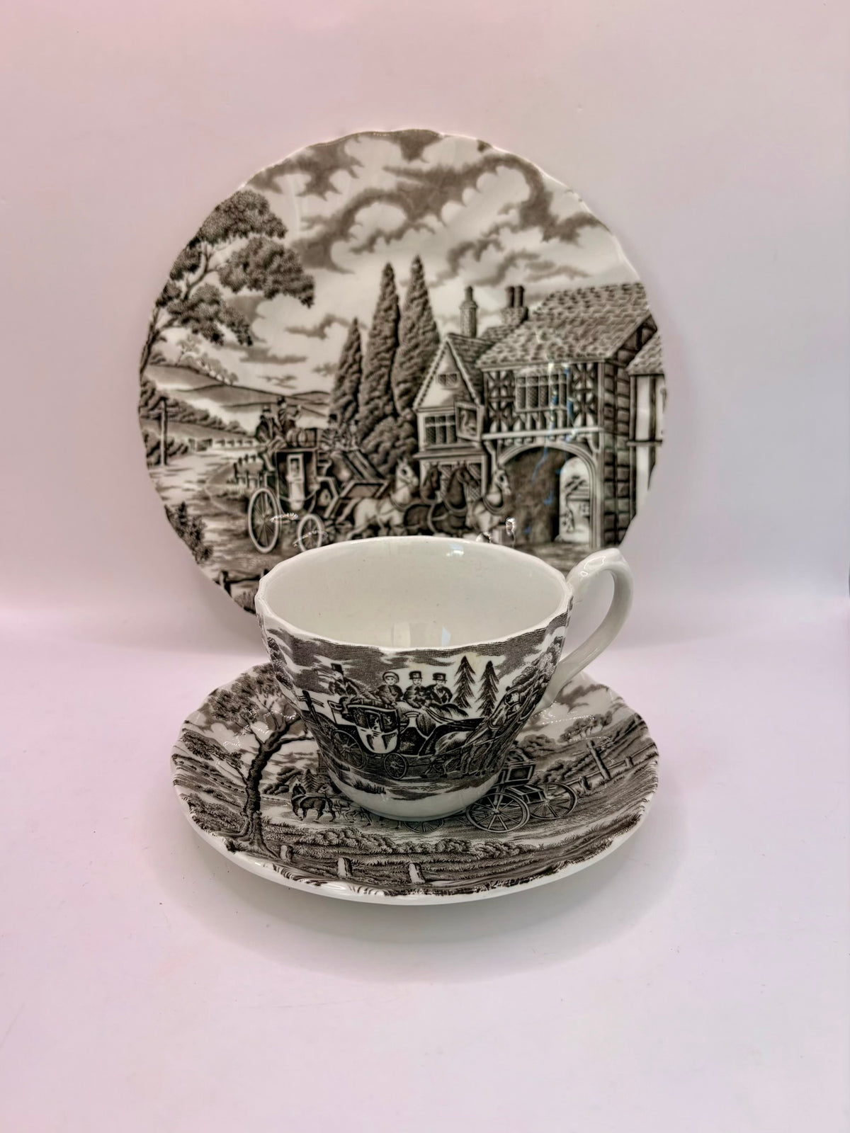 Ceramic teacup and saucer set with scenic design on a white background