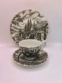 Ceramic teacup and saucer set with scenic design on a white background