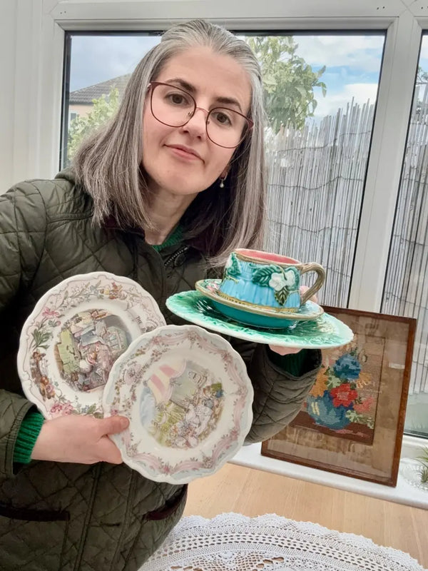 A women holding two plates and a cup in her hands.