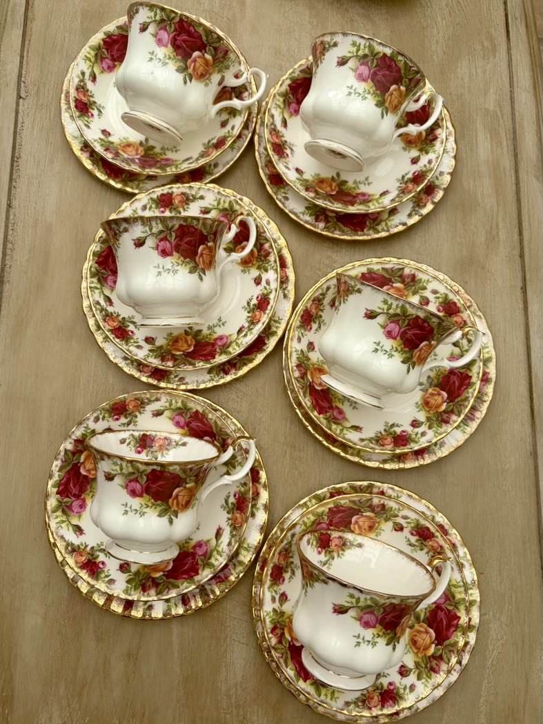 Set of floral teacups and saucers on a wooden surface