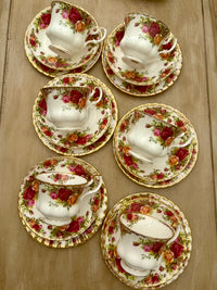 Set of floral teacups and saucers on a wooden surface
