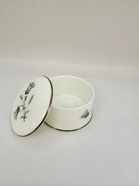 Round vintage porcelain trinket box with floral design and lid
