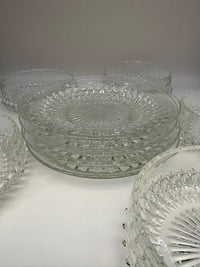 Vintage clear glass dessert set with diamond cut pattern, including bowls, saucers, and a serving plate