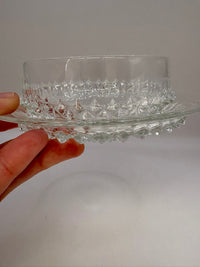 Vintage clear glass dessert set with diamond cut pattern, including bowls, saucers, and a serving plate