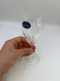 Clear glass with a brand logo held by a hand on a white background