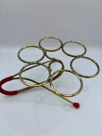 Gold metal rings with red strings on a white background
