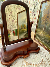 Detail of carved mahogany elements on antique Victorian vanity mirror