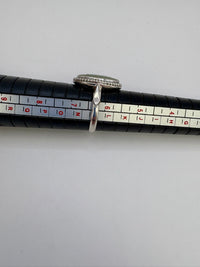 One silver ring on a black measuring tape with measurement scale.