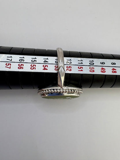 Silver ring with beaded design on a measuring tape for size reference