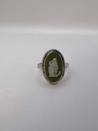 Silver ring with a green oval stone and engraved design on a white background