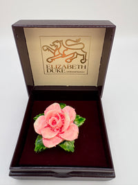 Pink rose brooch in a 'Elizabeth Duke' box on a white background