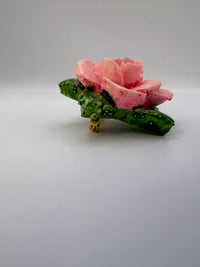 Pink flower with green leaves on a white background