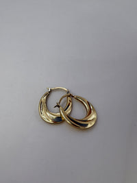 Gold hoop earrings on a light gray background