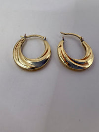 Gold hoop earrings on a light gray background