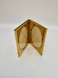 Gold compact mirror with two oval lenses on a white background