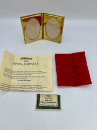 Brass photo frame with red carrying case and Marks & Spencer packaging on a white background