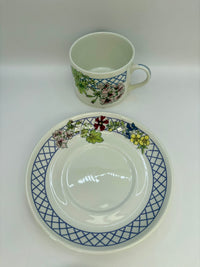 Ceramic cup and saucer with floral and geometric design on a white background