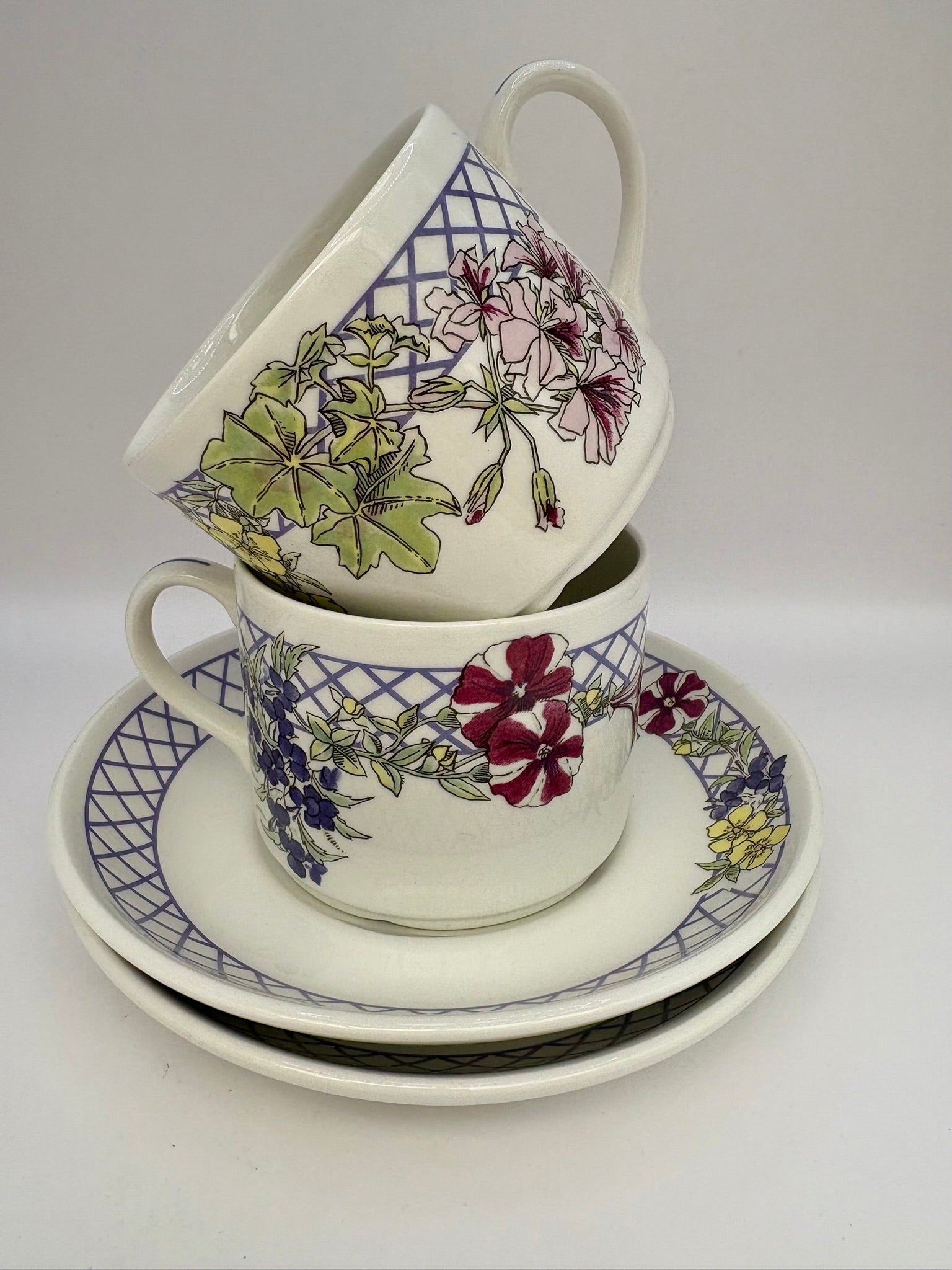 Stack of floral teacups and saucers on a white background