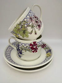 Stack of floral teacups and saucers on a white background