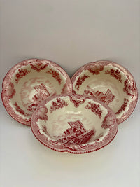 Three red and white ceramic bowls with vintage design on a light gray background