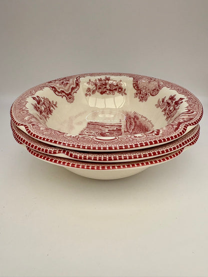 Set of three red and white patterned bowls on a light gray background