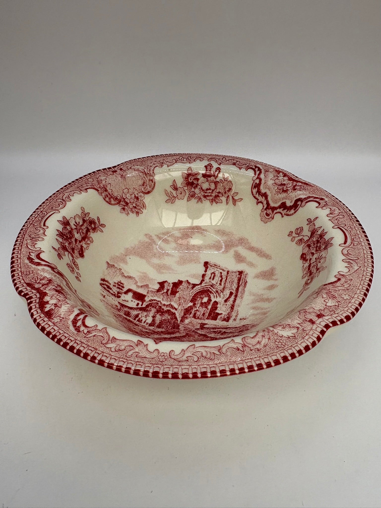 Decorative ceramic bowl with red and white pattern on a white background