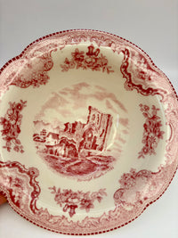 Decorative plate with red floral and architectural design on a white background