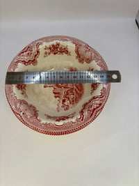 Red and white patterned plate with a ruler for scale on a white background