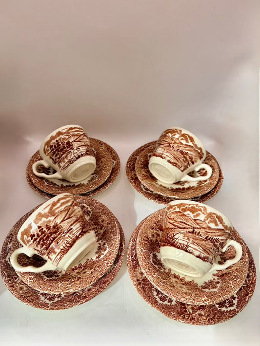 Four ceramic teacups with saucers on a white background