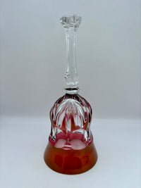 Decorative glass bell with clear top and red base on a white background