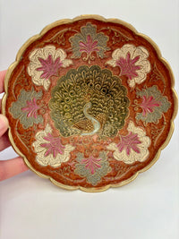 Decorative plate with peacock design on a white background