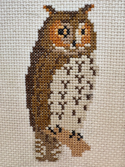 Cross-stitched owl on fabric with a neutral background