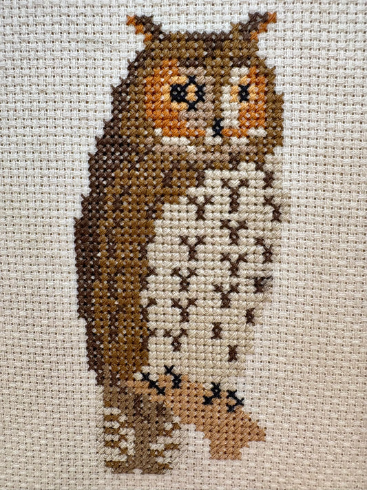 Cross-stitched owl on fabric with a neutral background