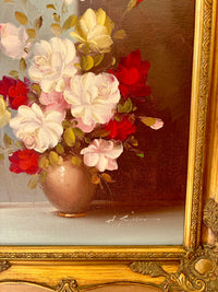 Floral arrangement in a vase with a gold frame