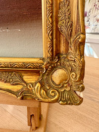Decorative gold frame on a wooden easel