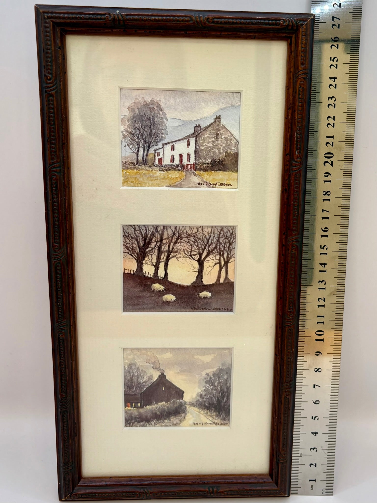 Framed set of four landscape prints with a ruler for scale on a white background
