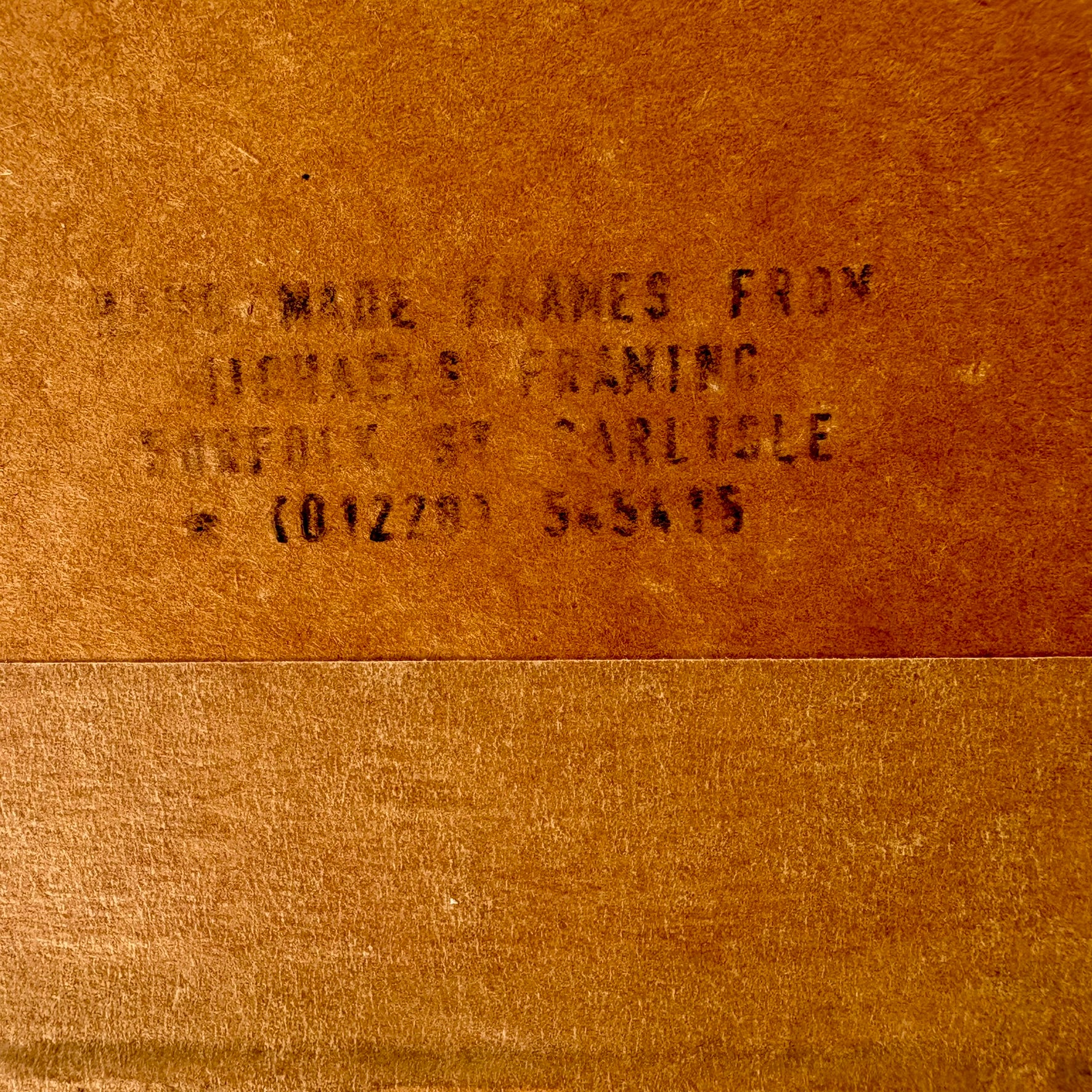 Text on a brown leather surface, likely indicating a brand or product name.