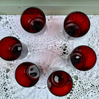 Red glass tumblers on a white lace tablecloth