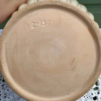 Close-up of a ceramic plate with a visible brand name on a white lace tablecloth.