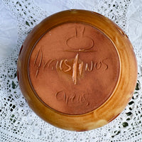 Round brown container with 'Augustinos Creas' branding on a white lace background