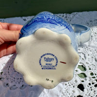 Ceramic windmill with 'Royal Worcester' branding on a lace tablecloth