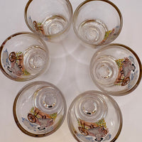 Set of six clear glasses with decorative designs on a white background