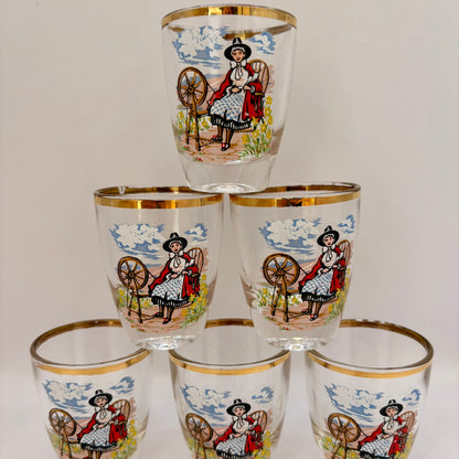 Set of six shot glasses with decorative designs on a white background